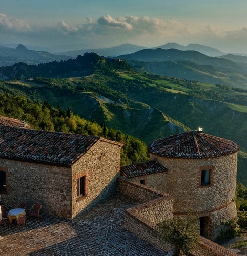 Immagine con montagne, verde, torre, nuvole, cielo, alberi, finestre, castello, tetti, panorama, paesaggio, tetto, pietre, cime, tegole, colline, tavolo, mattoni, borgo